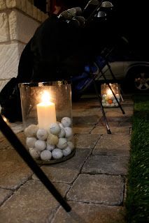 a lit candle sitting on the ground next to some rocks