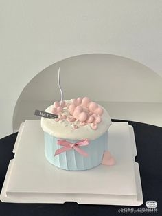 a cupcake with pink and blue icing on a white plate