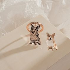 a small dog sitting next to a keychain on top of a white box