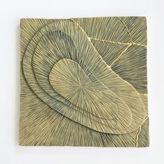 a piece of art made out of wood with lines and shapes on the bottom side