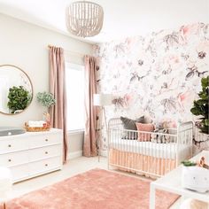 a baby's room with floral wallpaper and pink rugs on the floor