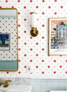 the bathroom is decorated with red and white stars on the wall, along with gold fixtures