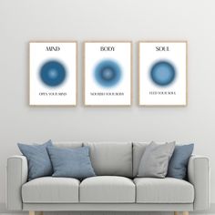 three blue circles are hanging on the wall above a couch in a room with white walls