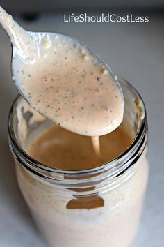 a spoon full of dressing sitting in a jar