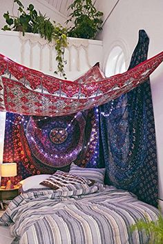 the bed is covered with many colorful blankets and lights on it's headboard