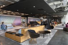 an office lobby with couches, chairs and tables in the middle of the room