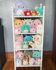 a white shelf filled with lots of stuffed animals