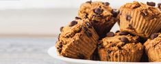 chocolate chip muffins piled on top of each other in a white bowl