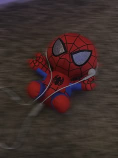 a spider - man stuffed animal is sitting on the ground