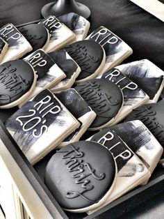 black and white decorated cookies sitting on top of a table