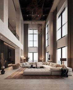 a large living room with high ceilings and lots of windows on the wall, along with white couches