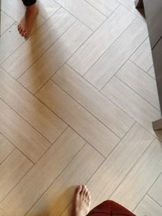 two people standing on the floor with their feet up