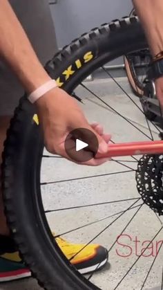 a person is fixing the spokes on a bicycle tire with a wrench and screwdriver