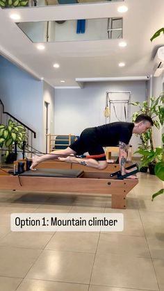 a man is doing an exercise on a wooden bench in the middle of a living room