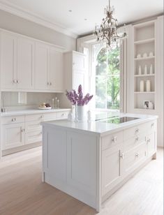 a white kitchen with an island in the middle