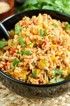 a bowl filled with rice and vegetables next to a fork