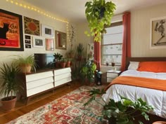 a bed room with a neatly made bed and lots of plants