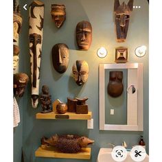 there are many african masks on the wall in this bathroom, and one has a hedgehog figurine