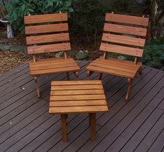 three wooden chairs sitting on top of a wooden deck