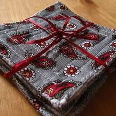 three cloths tied together on a wooden table with a red ribbon around the edges