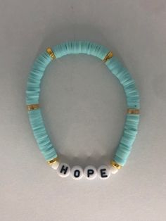 a beaded bracelet with the word hope written in white letters on top of it