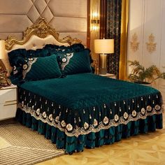 a bed with green bedspread and gold trimmings in a fancy bedroom