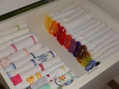 a drawer filled with lots of different colored towels and other items on top of it