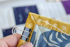 a person is stitching something on a piece of fabric with a pair of scissors