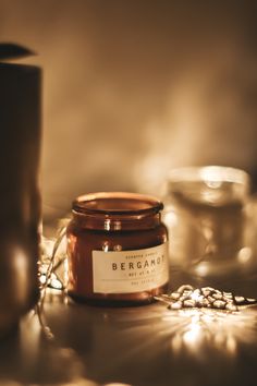 a candle sitting on top of a table next to a glass jar and some other items