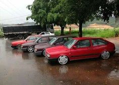 several cars parked in a row on a wet road