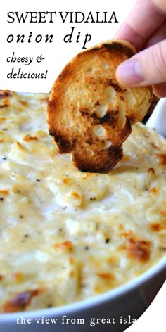 a hand dipping a piece of bread into a casserole