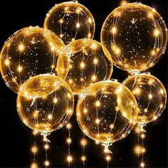 lighted balloons are arranged in the shape of balls on a black background with white lights