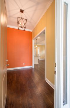 an empty room with wood floors and orange walls