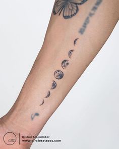 a person with a butterfly on their arm and phases of the moon in front of them