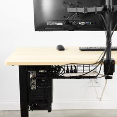 a computer monitor sitting on top of a wooden desk next to a keyboard and mouse