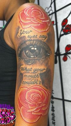 a woman's arm with an eye and roses on it