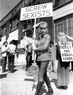 an old black and white photo of a woman holding a sign that says screw sexists