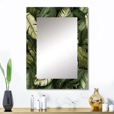 a mirror sitting on top of a wooden table next to a vase and potted plant