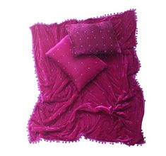 a pink bed with two pillows on top of it and a pillow case in the middle