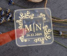 a close up of a person's hand holding a metal plaque with the word mn on it