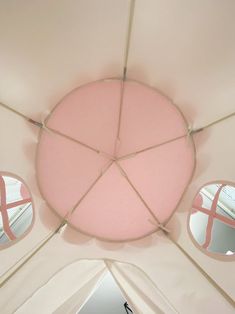 the inside of a pink tent with mirrors on it