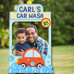 a man holding a child in front of a car wash sign