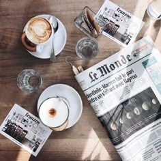 newspapers and cups of coffee on a wooden table