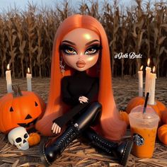 a doll sitting on the ground next to pumpkins and candles