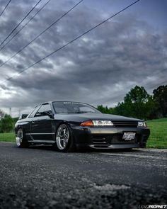 the car is parked on the side of the road in front of some power lines