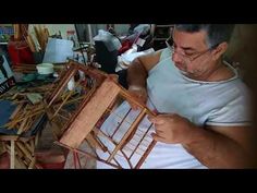 a man is working on an object in his workshop with wood sticks and plywood