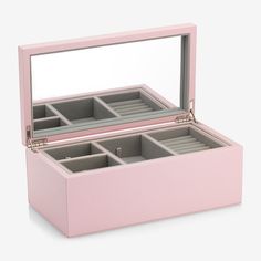 an open pink jewelry box with compartments on the bottom and inside, sitting on a white surface