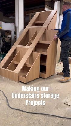 a man standing next to a wooden staircase in a garage with the words making our understairs storage projects