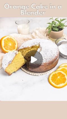 orange cake in a blender on a table with sliced oranges and powdered sugar