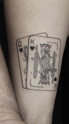 a black and white tattoo on the leg of a man with a playing card design